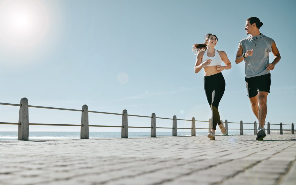 Couple, fitness and running by beach on mockup for exercise, workout or cardio routine together. Happy man and woman runner taking a walk or jog for healthy wellness or exercising